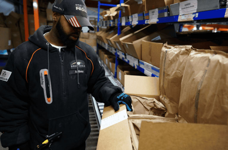 Worker preparing temperature-controlled food orders for parcel shipment at a refrigerated fulfillment facility