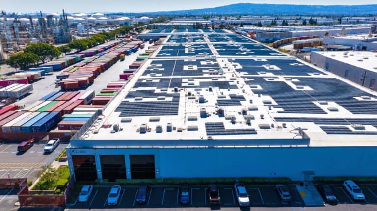Warehouse rooftop solar panels on Prologis logistics facilities supporting California community solar programmes for residential electricity.